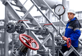 a man looking at the pipes and gauges of a sf6 gas plant